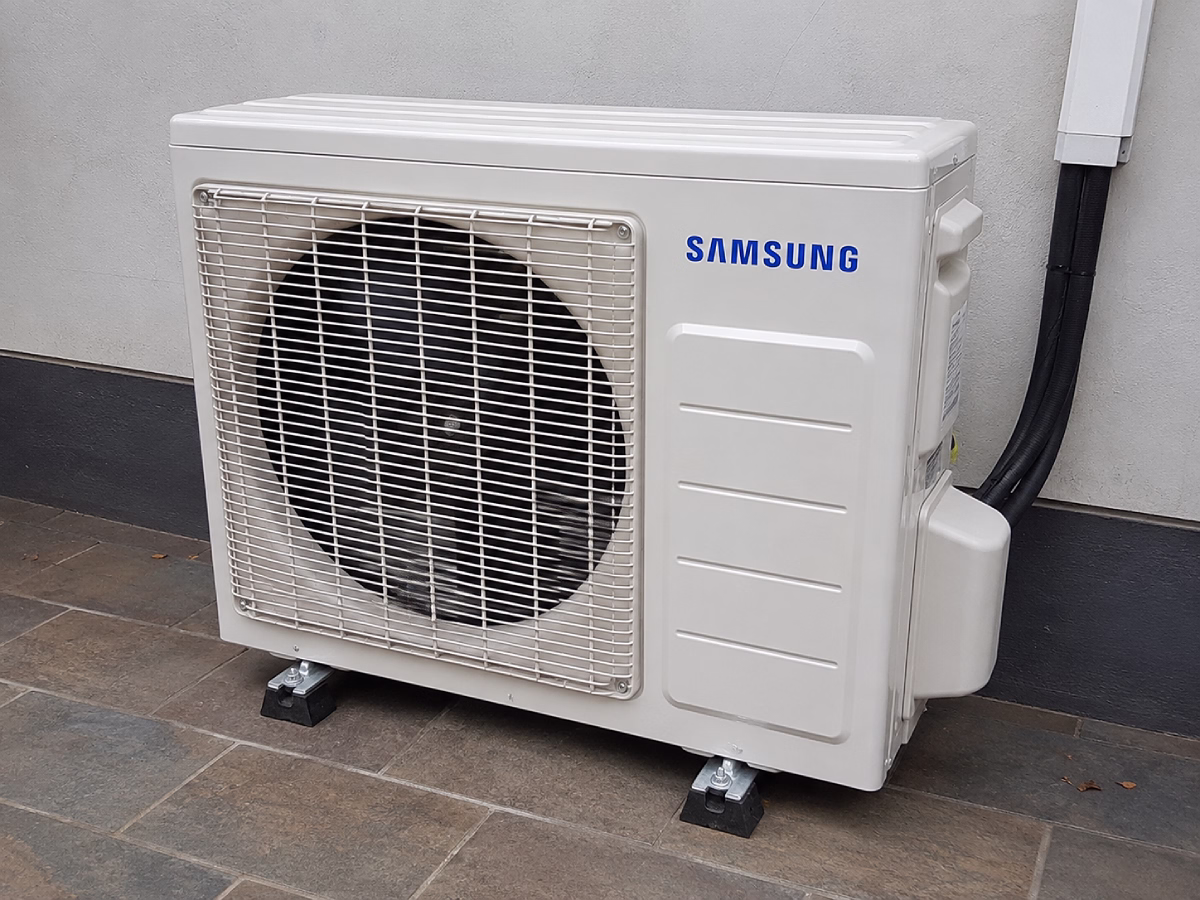 Samsung outdoor condenser unit mounted on rubber feet with a neat pipe run