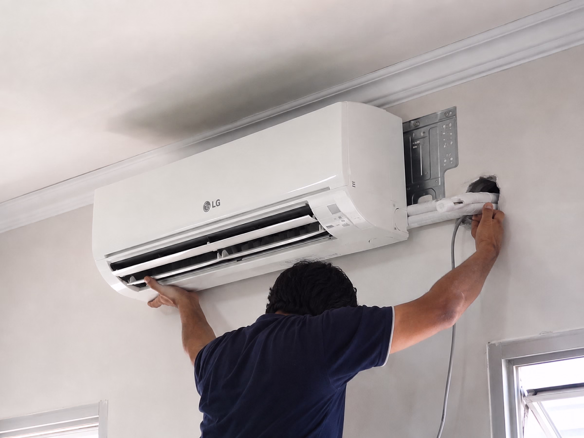 Meridian Air technician fitting an LG indoor unit to its wall bracket